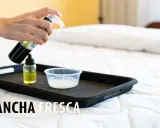 Persona rocía líquido de una botella sobre una bandeja con un recipiente pequeño. Aprende como desinfectar un colchon.