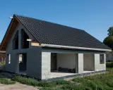 Dom w stanie surowym otwartym, z dachem pokrytym czarną dachówką. Widoczne betonowe ściany i otwory okienne oraz drzwiowe.