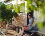 Frau arbeitet auf Laptop vor einem Tiny House. Ein Beispiel für modernes, flexibles wohnen in der zukunft.