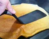 Volteando un crepé dorado en una sartén, preparado fácilmente con crepes thermomix.