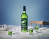 O.P. Anderson Gunpowder i gröna shotglas på ett bord med is och tic-tac-toe-ritningar.