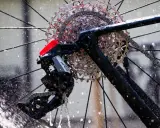 Błyszczące, elektryczne przerzutki SRAM Apex na rowerze, obmywane przez strumienie wody.