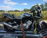 Srebrny motocykl na przyczepce, gotowy do transportu. Może to być związane z akcyzą na motocykle, która wpływa na koszty zakupu.