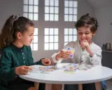 Deux enfants jouent à un jeu de cartes coloré, une belle illustration d'activités sans écran pour adultes et enfants.
