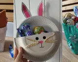 Schnelles Ostern basteln: Drei süße Osterkörbchen aus Papptellern und Stoffresten, gefüllt mit Schokoladenhasen und -eiern.
