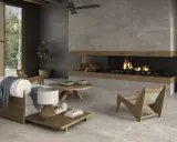 Salón moderno con chimenea encendida, sofá blanco y suelo de cemento pulido.