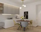Ingresso su sala da pranzo con tavolo rotondo, sedie, cucina moderna e scaffali a muro.