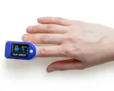 Fingerspitze mit Pulsoximeter, das den Puls beim Spazieren misst.