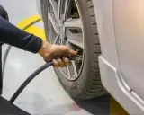 Sprawdzanie ciśnienia w oponach rowerowych 20 cali. Dłoń z wężem podłącza się do wentyla, by napompować koło.