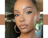 Un teint de peau lumineux et naturel, sublimé par un maquillage subtil et des boucles d'oreilles dorées.