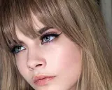 Primer plano de una mujer con flequillo rubio desfilado, delineado de ojos dramático y labios rosados. Muestra varios tipos de flequillo.