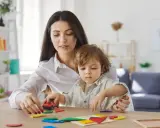 Mama i dziecko bawią się klockami. Zastanawiasz się, ile może zarobić dziecko, żeby nie stracić alimentów?