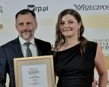 Mężczyzna i kobieta odbierają nagrodę w ramce z napisem "Ranking Kancelarii Prawniczych".