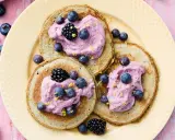 Tre fluffiga pannkakor med havregryn toppas med lila grädde, blåbär och björnbär. Strössel av citronskal ger en frisk touch.