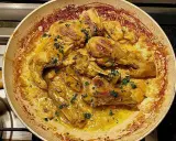 Succulento pollo alla marengo in padella, con erbe aromatiche fresche e una ricca salsa dorata.