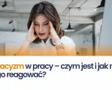 Kobieta z dłońmi na skroniach, zestresowana. Temat: ostracyzm w pracy – czym jest i jak na niego reagować?