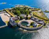 Överblicksbild av Karlsborgs fästning, en viktig del av Karlskrona historia, med sina befästningar, byggnader och omgivande vatten.