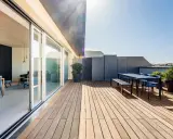 Modernes Einfamilienhaus mit großzügiger dachterrasse. Holzboden, Sitzgruppe und Pflanzen laden zum Verweilen ein.