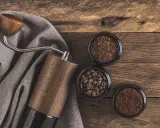 Holz-Kaffeemühle mit drei Behältern: ganze Bohnen, grob gemahlener und feiner, kleiner brauner Kaffee.