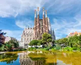 La Sagrada Familia, con le sue torri svettanti e il riflesso sull'acqua, sembra un sogno che attende il suo completamento. Chissà quando finirà la Sagrada Familia.