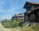 Drewniane wille w osadzie Czorsztyn, z charakterystyczną architekturą i zielenią, zapraszają do podróży w czasie.