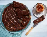 Chokladkaka med kolasås och havssalt, perfekt att baka glutenfritt. En bit lyfts upp med en kniv.