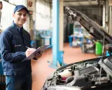 Uśmiechnięty mechanik notuje przebieg auta przed pierwszą wymianą oleju w silniku 1.5 TSI.