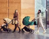 Dwie kobiety spacerują z wózkami Kinderkraft Route. Jedna w beżowym płaszczu, druga w jasnym.