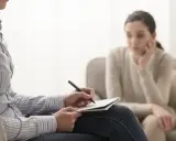 Psycholog kliniczny notuje podczas sesji. Zastanawiasz się, ile zarabia psycholog kliniczny prywatnie?