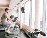 Mężczyzna ćwiczy na rowerze stacjonarnym, który może być dobrym wyborem, jeśli zastanawiasz się, jaki rower stacjonarny do rehabilitacji kolana.