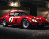 Roter Ferrari 250 GTO, das seltenste Auto der Welt, mit der Startnummer 7, steht vor einer Garage.
