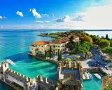 Sirmione, uno dei **laghi di Garda posti più belli**, con il suo castello medievale e le acque cristalline.