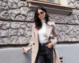 Elegancka kobieta w beżowym płaszczu i ciemnych jeansach. Spódnica jeansowa midi stylizacje na co dzień.