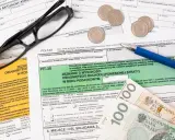 Okulary, długopis i pieniądze leżą na dokumentach podatkowych. Zastanawiasz się, co można odliczyć w PIT?