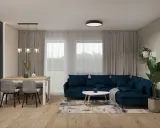 Nowoczesny salon z granatową kanapą i stołem. Dwie lampy wiszące nad stołem i jedna sufitowa tworzą przytulną atmosferę.