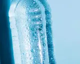 Krople wody na plastikowych butelkach, sugerujące, czy można zamrozić wodę w butelce plastikowej.