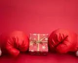 Rękawice bokserskie w świątecznym stylu otaczają prezent. Czy to zapowiedź, boxing day co to znaczy?