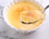 Une cuillère de semoule au lait et aux œufs, avec sa croûte caramélisée dorée, prête à être dégustée.