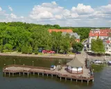 Malownicze Mazury: molo, urokliwe miasteczko i zielone drzewa. Idealne miejsce, gdzie najlepiej na Mazury.