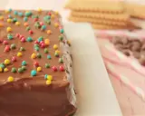 La tarta de la abuela, cubierta de chocolate y chispas de colores, lista para ser disfrutada.
