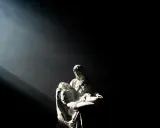 Kamienna Pieta w mroku, oświetlona snopem światła. Czy to kara za poprzednie wcielenie?