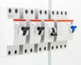 Szereg wyłączników nadprądowych. Na jednym z nich widoczny dobór bezpiecznika do mocy wzór: 25A, U=230V.