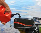 Un homme verse de l'essence dans un moteur hors-bord. Il se demande quel essence pour moteur 2 temps utiliser pour sa sortie en bateau.