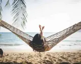 Relaks na plaży w hamaku, idealny opis wakacji po angielsku. Słońce, morze i palmy tworzą rajski widok.