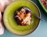 Un délicieux crumble poire chocolat, servi dans une assiette verte craquelée, avec une cuillère en argent.