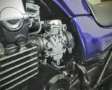 Silnik motocykla z gaźnikiem i fioletowym bakiem. Gotowy do dolotu i dalszej jazdy.