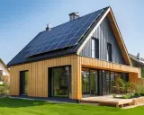 Une maison bioclimatique moderne avec panneaux solaires sur le toit, bardage bois et grandes baies vitrées, profitant du soleil.