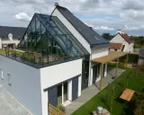 Maison moderne avec toit en verre spectaculaire, terrasse végétalisée et pergola en bois. Un rêve de maison ecc.