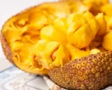 Odkryj smak jackfruit po polsku! Soczyste, żółte miąższowe segmenty owocu w skorupie.