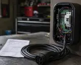 Componenti interni di punti ricarica auto elettriche, con cavo e connettore in primo piano.